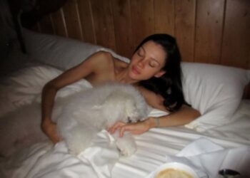 Brooklyn shared a photo of Nicola in bed cuddling with their dog.