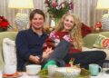 Josh Hartnett and Tasmin Egerton sat down on a sofa, smiling ahead.