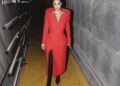 Kim Kardashian in a bold red Balenciaga tailored coat styled with black boots, a striking take on modern celebrity new year outfits.
