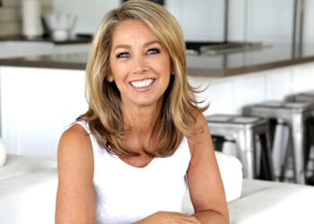 A close-up of Denise Austin smiling in a white tank top.