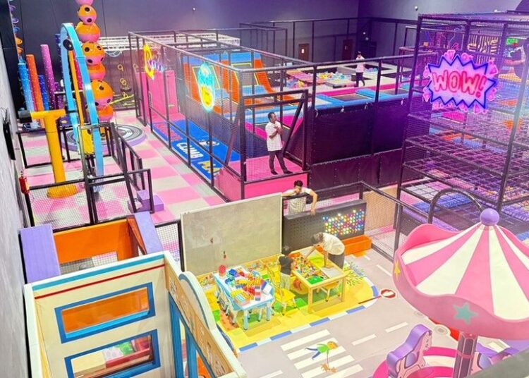 Colorful indoor playground with slides, ball pits, and play structures for children.