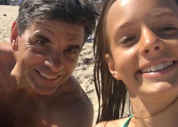 George posing in a rare beach photo with his daughter