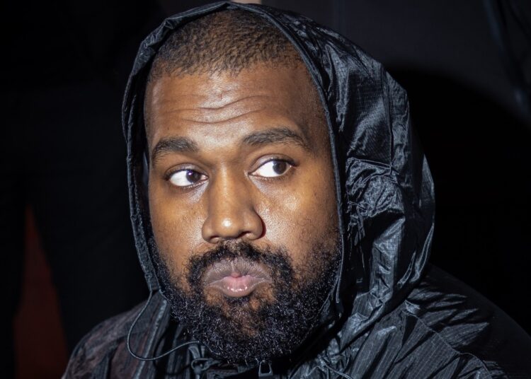 Kanye West wearing a black hooded jacket.