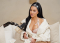 Kim Kardashian speaking into a microphone on a podcast.