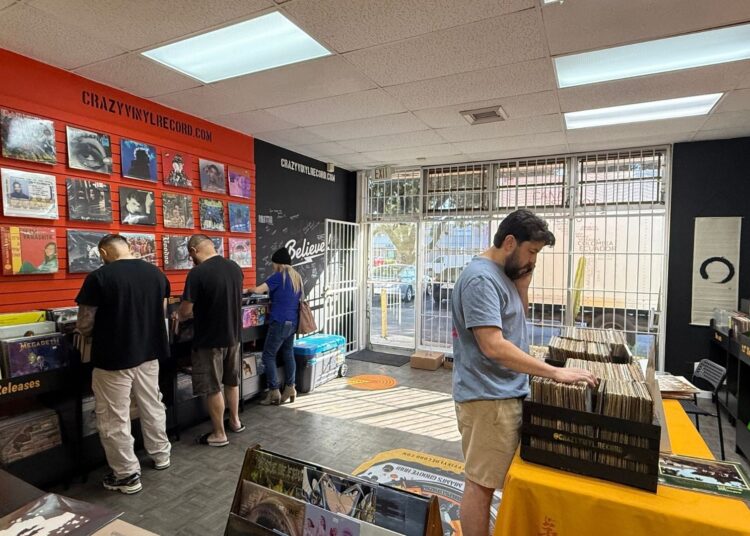 People at a store digging through vinyl