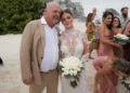 Rick Harrison wears tan suit with wife Angie in white bridal gown.