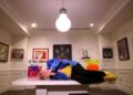 A man lays on a bench in an art gallery.