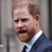 Prince Harry turns to the cameras and is pictured in the middle of speaking. His mouth is open.