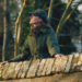 Princess Kate standing on a bridge in a green coat