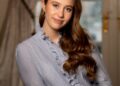 Princess Josephine wearing a blue blouse leaning on a table