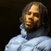 XL Recordings Jim Legxacy pictured outdoors at night in a light blue puffa jacket