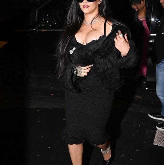 Rihanna exiting a vehicle, wearing a black outfit.