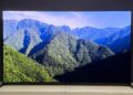 The 55-inch Sony Bravia 8 II QD-OLED TV photographed on a white table. On the screen is a nature documentary.