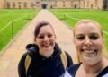 Lauren and Brianna take a smiling selfie in the middle of a university grounds.