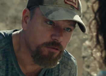 Matt Damon as Bill Baker wearing a hat and speaking to someone in Stillwater