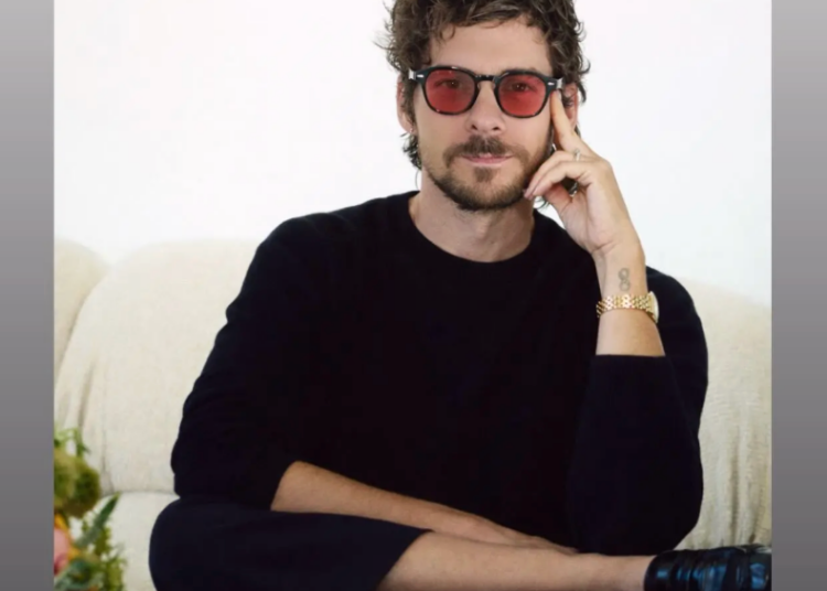 promotional graphic featuring a person seated on a couch with text about an interview