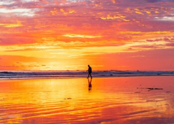 A man walks on the beach at sunset in Uvita.