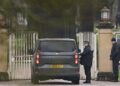 A police officer talks to a driver inside a car outside Royal Lodge on the Windsor Estate.