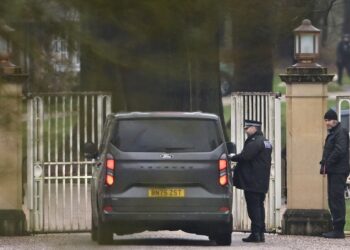 A police officer talks to a driver inside a car outside Royal Lodge on the Windsor Estate.