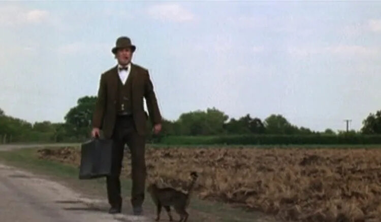 Robert Duvall's Mr. Cox stands alongside his cat on a rural road in The Stars Fell in Henrietta