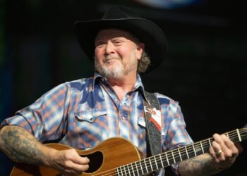Tracy Lawrence strums guitar on stage