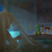 In a scene from Disney and Pixar’s Toy Story 5, we are looking at a darkened bedroom from the head of a twin bed. Directly in front of us, on the left side of the image, a mysterious person, probably a child, is silhouetted beneath a blue polka-dot sheet, holding a computer tablet that has them entranced. At the end of the bed, peeking over the foot of the bed and lit by a beam of moonlight, are many of the Toy Story characters, including Woody, Jessie, and Buzz.