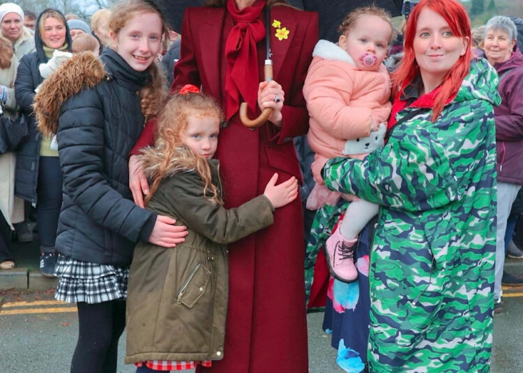 Catherine, Princess of Wales, takes a moment to greet young well-wishers during her visit to Wales.