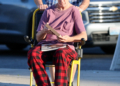 Andy Dick in a wheelchair, being pushed by a companion, on an afternoon outing in Los Angeles.