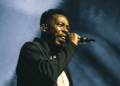 GZA of Wu-Tang Clan performing live on stage at Amalie Arena in Tampa during a June 2025 concert.