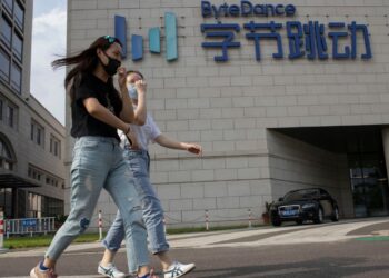 Women wearing masks to pass by the headquarters of ByteDance, owners of TikTok, in Beijing, China, Aug. 7, 2020. (AP Photo/Ng Han Guan)