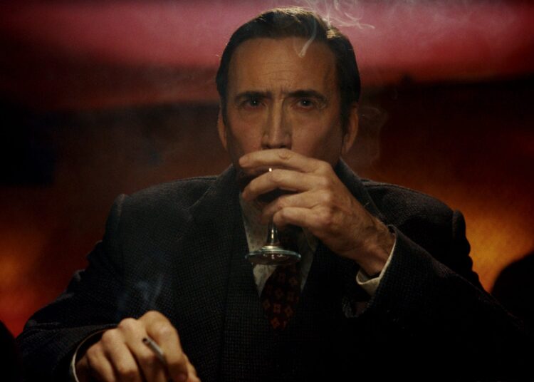 a man sitting at a table with a drink and a cigarette