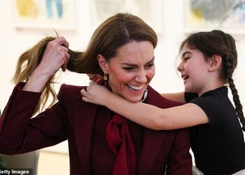Catherine, Princess of Wales, receives a necklace made by a child at an art workshop during a visit to a project funded by the Alexandra Reinhardt Memorial Award