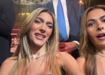 Two women with pained and surprised expressions react to a performance.