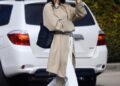 Kendall Jenner embraces high vamp ballet flats, white pants, and a woven bag