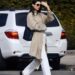 Kendall Jenner embraces high vamp ballet flats, white pants, and a woven bag