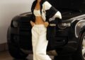 a person in a sporty outfit walks near a vehicle