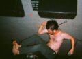 Image may contain Adult Person Clothing Pants Photography Face Head Portrait Barefoot Footwear and Shoe