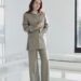 molly gordon in a tailored suit standing indoors