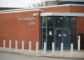 View of building exterior. Writing on the wall reads: "Police Investigation Centre"