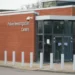 View of building exterior. Writing on the wall reads: "Police Investigation Centre"