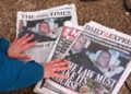 A journalist looks at newspaper front pages on Feb. 20, 2026.