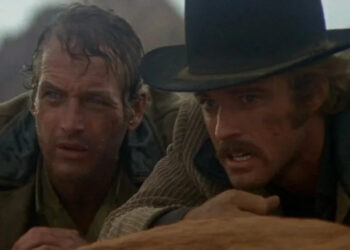 Paul Newman as Butch Cassidy and Robert Redford as the Sundance Kid crouching behind a rock in Butch Cassidy and the Sundance Kid