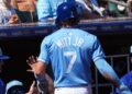 Mar 11, 2024; Surprise, Arizona, USA; Kansas City Royals shortstop Bobby Witt Jr. (7) returns to the dugout after scoring a run against the San Francisco Giants during the first inning at Surprise Stadium. Mandatory Credit: Joe Camporeale-Imagn Images