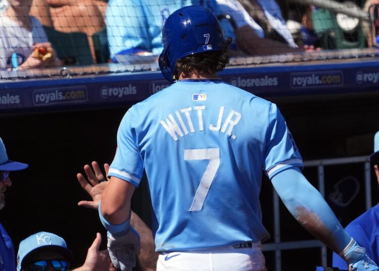 Mar 11, 2024; Surprise, Arizona, USA; Kansas City Royals shortstop Bobby Witt Jr. (7) returns to the dugout after scoring a run against the San Francisco Giants during the first inning at Surprise Stadium. Mandatory Credit: Joe Camporeale-Imagn Images