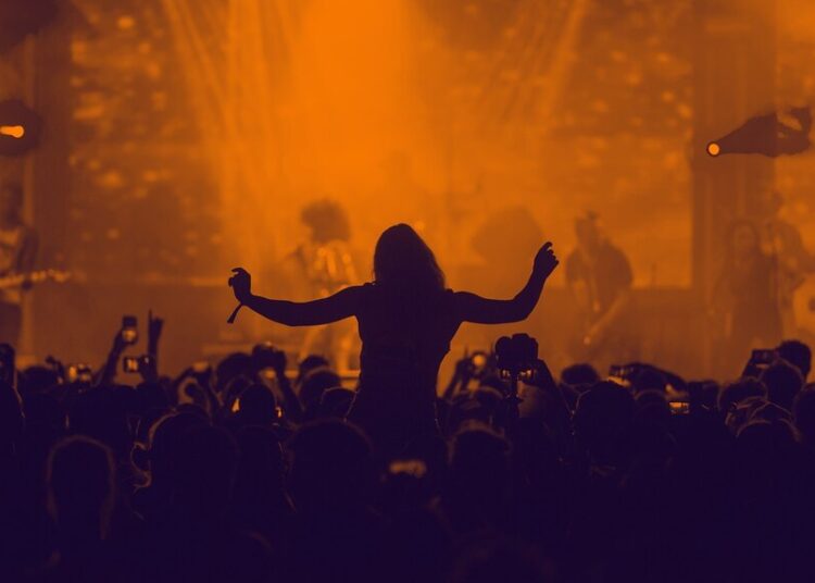 a woman on someone's shoulders in a crowd