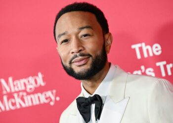 john legend smiles from a red carpet premiere