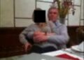 A blurry photo of a woman sat on a man's lap