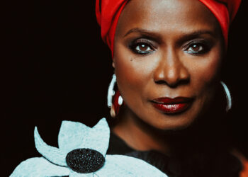 Angélique Kidjo - Photo by Brantley Gutiérrez. Angélique wearing a turban and a dress with a large flower on the shoulder.