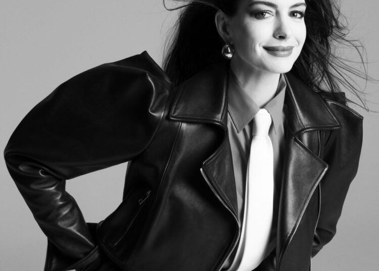 Fashion editorial featuring a model in a black leather jacket and white tie.