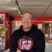 A man in a record store smiles at the camera